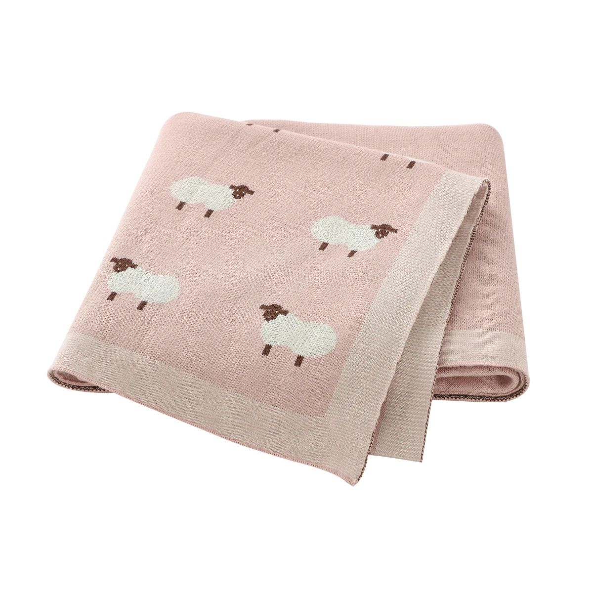 Couverture bébé rose en coton à motifs moutons, pliée sur fond blanc