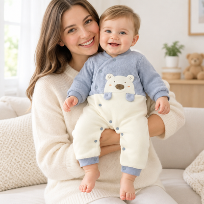 Bébé garçon porté par sa maman, tous deux souriants, pyjama bleu ourson