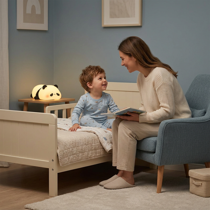 Garçon souriant à sa maman près de la veilleuse panda couché